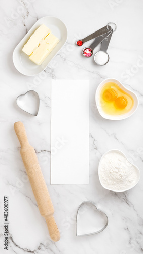 Mock up with white paper with space for text, around ingredients for baking cookies. Concept cooking with love, cooking for your loved ones, baking for valentines day. Copy space. Top view