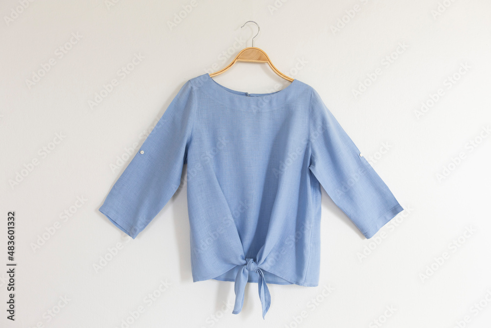 © Pornpawit - blue blouse on hanger. © Pornpawit - blue blouse on hanger.