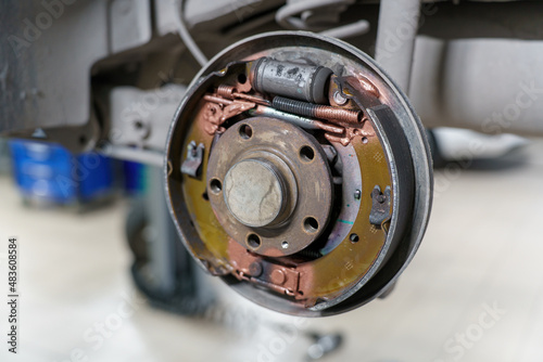 Automotive transmission. Rear brake drum. Maintenance and lubrication in garage on lift.