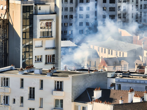Incendie d'une maison en centre ville avec la fumée se dégageant du toit