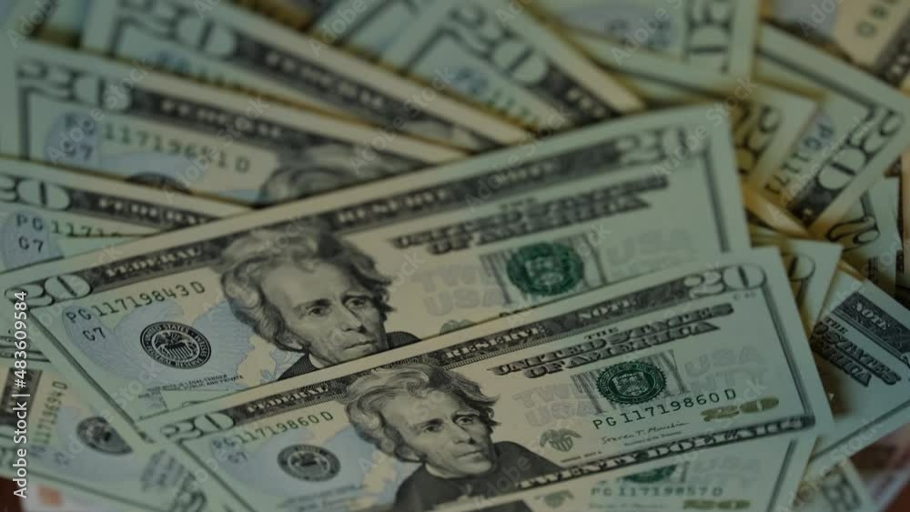 Twenty US dollar banknotes fall on the table with a spinning wad of money, close-up. 20 dollar american bills close up Twenty US dollar banknotes fall on the table with a spinning wad of money, close-up. 20 dollar american bills close up