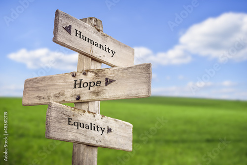 Fotografie, Obraz humanity hope equality text quote on wooden signpost outdoors on green field