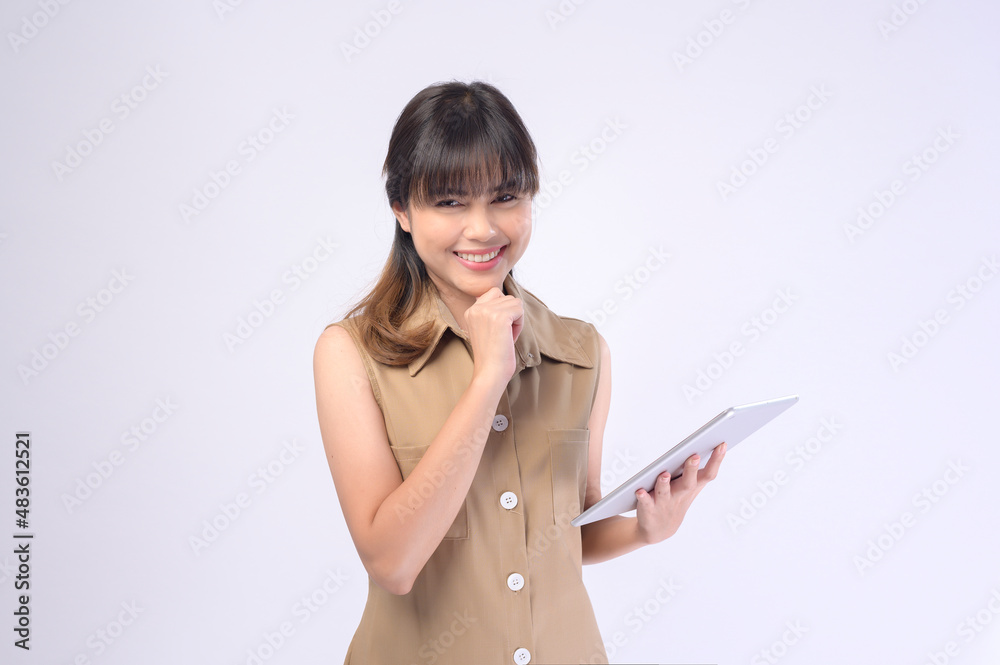 Portrait of young beautiful smiling woman is holding tablet over white background studio Portrait of young beautiful smiling woman is holding tablet over white background studio