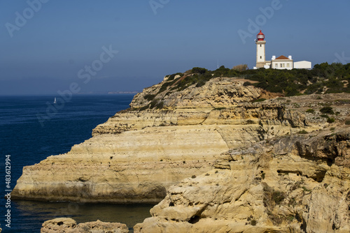 cliff and Beautiful Alfanzina Lighthouse in the coastal area of the Carvalho beach, Algarve, Portugal photo