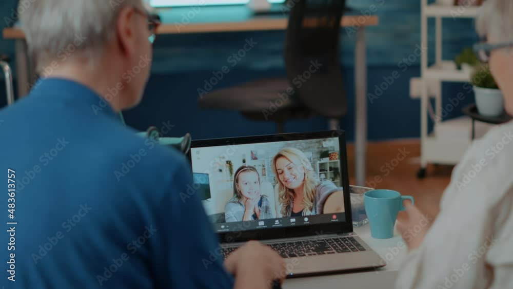 Grandparents using online conference on laptop computer to chat with family. Senior people talking to relatives on remote teleconference meeting, looking at screen. Telecommunication Grandparents using online conference on laptop computer to chat with family. Senior people talking to relatives on remote teleconference meeting, looking at screen. Telecommunication