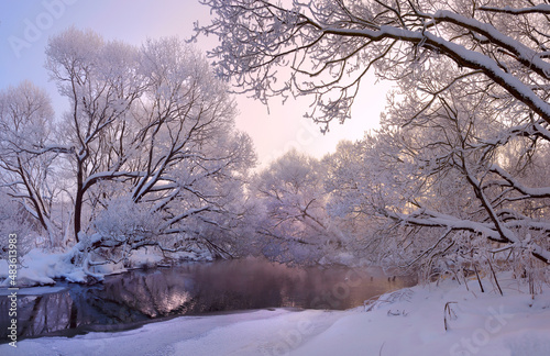 Winter frosty scene with forest river and snow covered trees