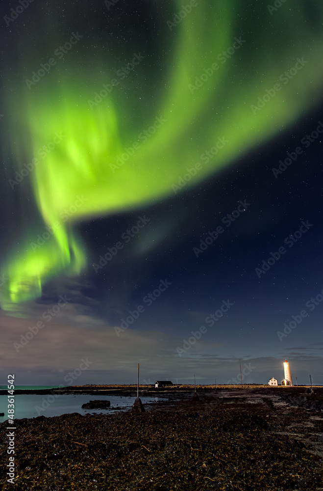 Spectacular show of the Northern Lights over Grotta Island lighthouse in Reykjavík - the capital of Iceland