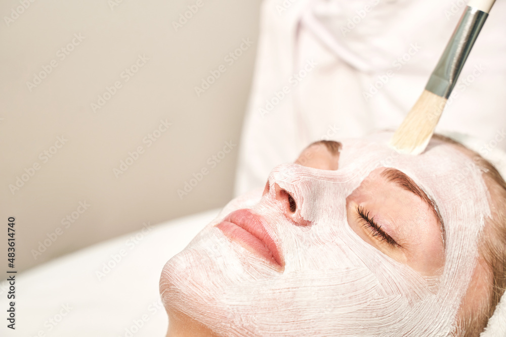 Naklejka premium Portrait of moisturizing clay mask for medical design. Woman skin procedure. Natural cosmetic products. Beauty face. Facial cosmetology treatment. Healthcare peeling cream