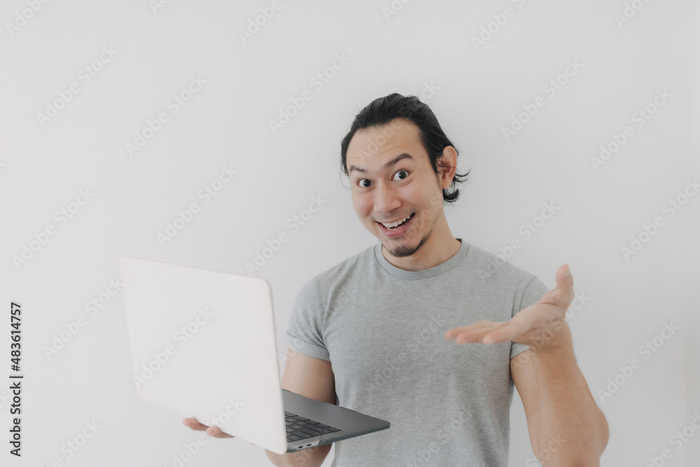 Shocked and surprised face of Asian man looking at the laptop in his hand. Shocked and surprised face of Asian man looking at the laptop in his hand.