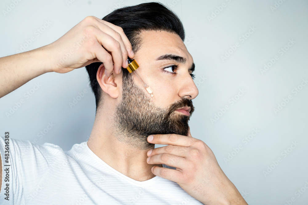 Obraz premium Bearded man holding pippete with beard oil 