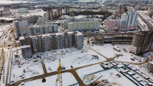 Construction site of a modern city block. High-rise buildings under construction. Construction tower cranes. Construction site in winter. Aerial photography at sunset. © f2014vad