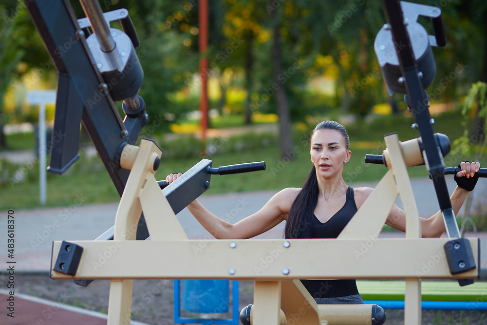 Φωτογραφία Sports girl doing fitness outdoors on sports simulators.