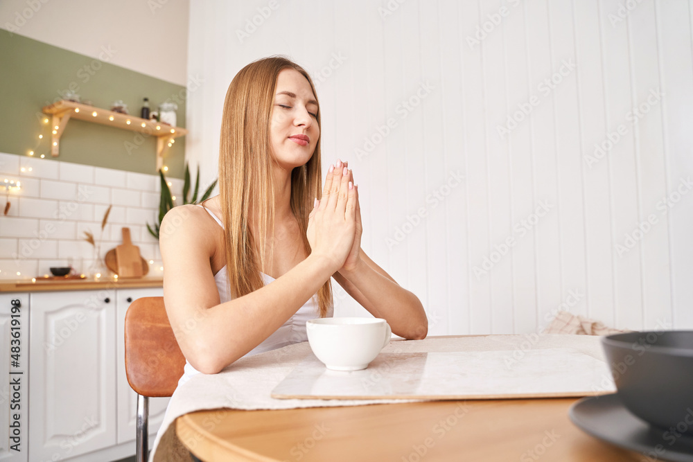 Young woman posing at kitchen. Home vacation portrait. Blogger. Alone in interior. Change emotion. Clam down. Smiling female person. Lifestyle action. House light background Young woman posing at kitchen. Home vacation portrait. Blogger. Alone in interior. Change emotion. Clam down. Smiling female person. Lifestyle action. House light background