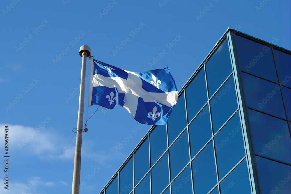 Obraz premium Quebec, Canada, Montreal north america french culture flag fluttering in the wind blue glass building