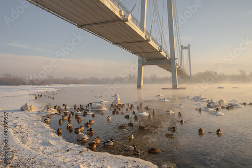 snow-covered bridge over the river in the winter in the sunrise Russia, Krasnoyarsk Vinogradovsky Bridge or Vantovy Bridge photo