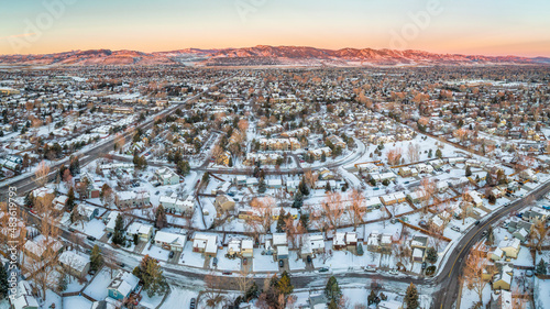winter dawn over residential area of Fort Collins and Rocky Mountains foothills in northern Colorado after snowstorm, aerial view