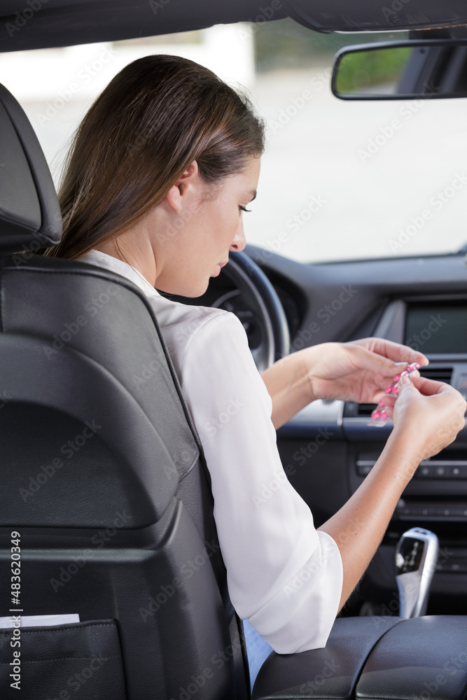 woman with tablets at the steering wheel of a car