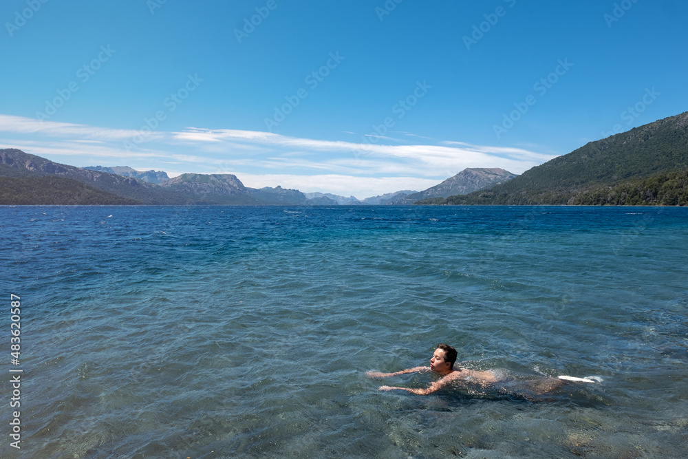 Person swimming on the lake in the mountains	

