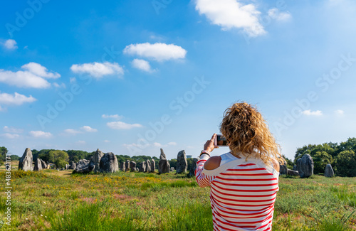 woman taking photo at Carnac alignments in France. photo