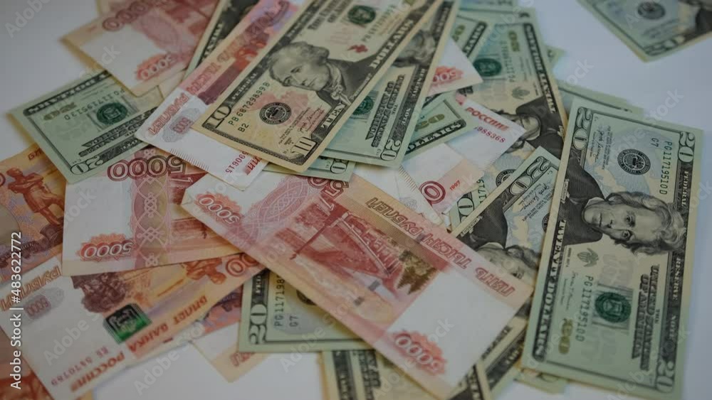 Russian and American paper bills of dollars and rubles fall on the table in turn. US dollar money rain Russian and American paper bills of dollars and rubles fall on the table in turn. US dollar money rain