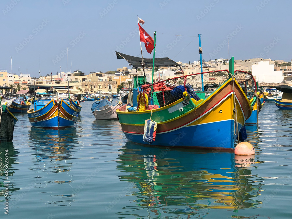 brightly colourful Maltese fishing boats docked in harbour  