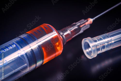 Syringe with drugs close-up on a dark background