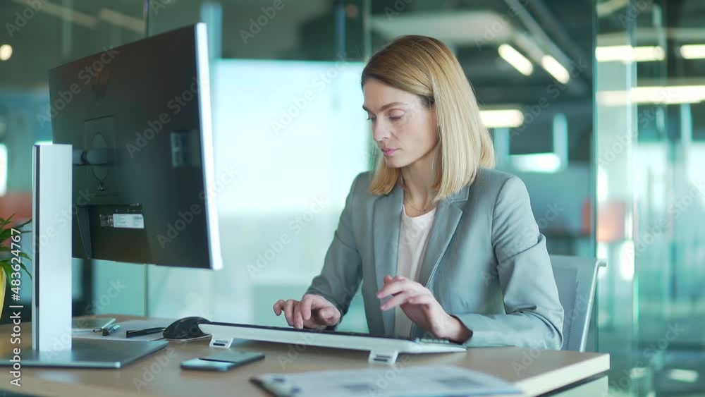 Female office worker in suit working at computer pc in front of monitor correspondence sitting at desk. employee in a modern workplace. Blonde woman Busy entrepreneur secretary typing text message Female office worker in suit working at computer pc in front of monitor correspondence sitting at desk. employee in a modern workplace. Blonde woman Busy entrepreneur secretary typing text message