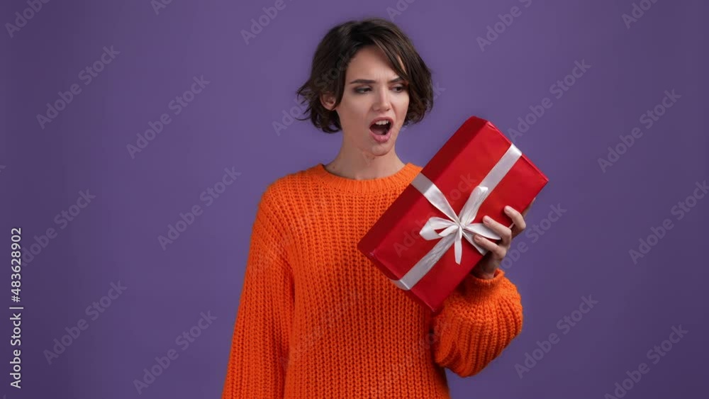 Amazed lady get package upset not like isolated vivid color background Amazed lady get package upset not like isolated vivid color background