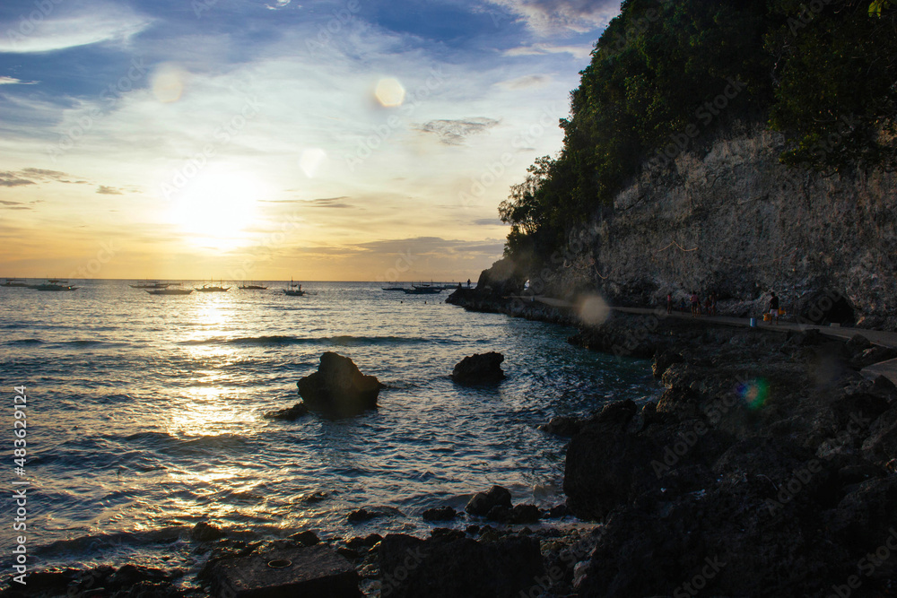 Sunset on the coast. Sea and sand. Sunset light. Beautiful nature. Seascape. Tropical climate. Philippines. Boracay Island. Exotic nature.