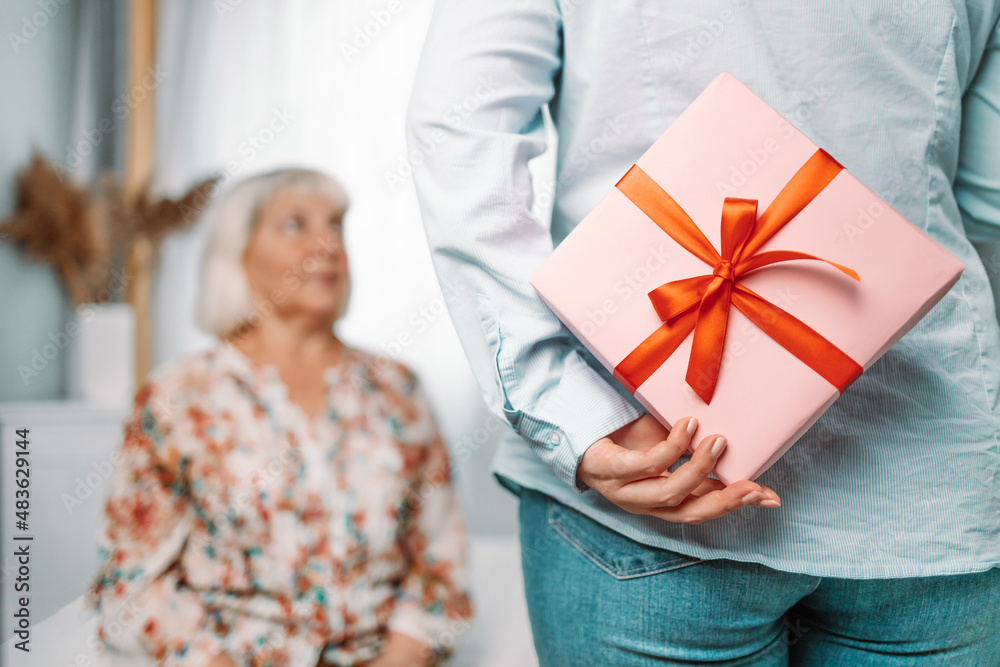 Gift for mother. Young caucasian daughter gives her mom a gift Gift for mother. Young caucasian daughter gives her mom a gift