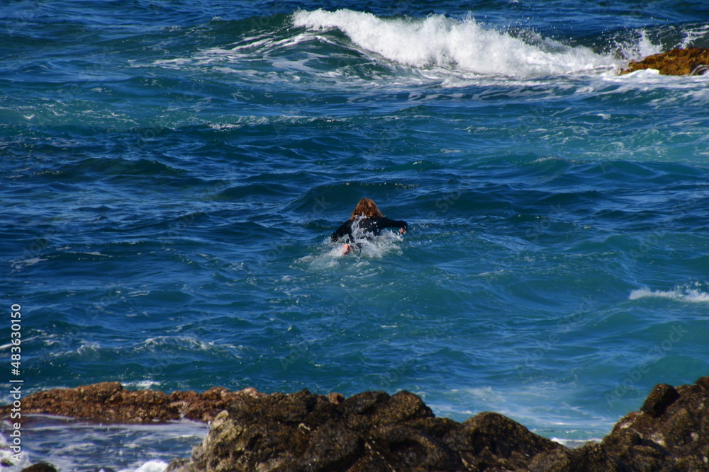 Fototapeta premium SURFERO EN UNA COSTA ROCOSA