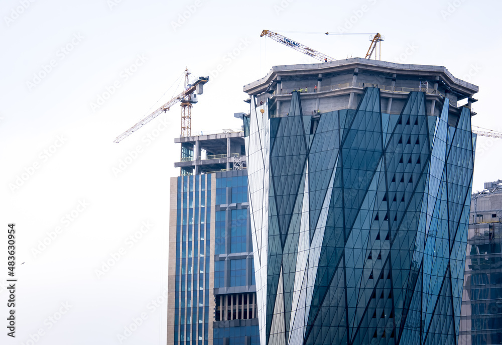 construction of skyscrapers and cranes, office buildings with glass facades, selective focus