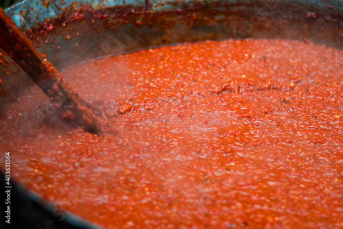 Cooking red bell peppers, tomatoes, eggplants over a fire to make national delicious Bulgarian lyutenitsa tomato sauce. . High quality photo