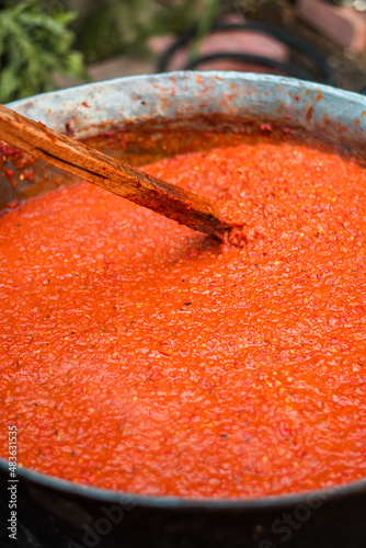 Cooking red bell peppers, tomatoes, eggplants over a fire to make national delicious Bulgarian lyutenitsa tomato sauce. . High quality photo photo