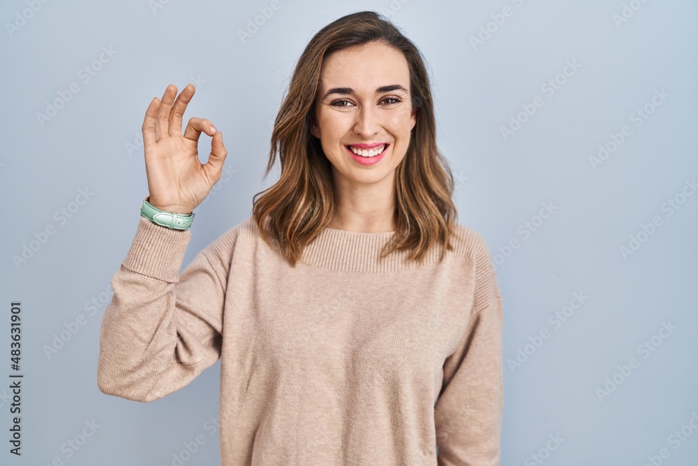 Young woman standing over isolated background smiling positive doing ok sign with hand and fingers. successful expression. Young woman standing over isolated background smiling positive doing ok sign with hand and fingers. successful expression.