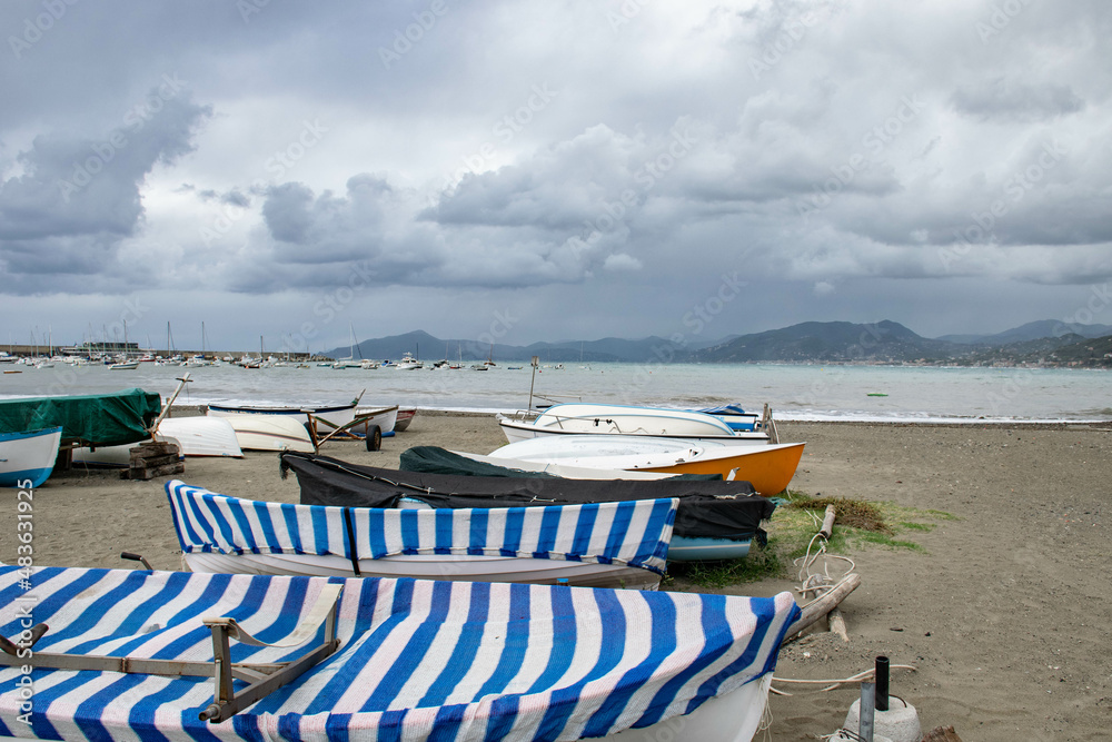 Cinque Terre, Sestri Levante, Italy, Liguria, September 2017. boats on a deserted beach, sea view, bay and cloudy sky