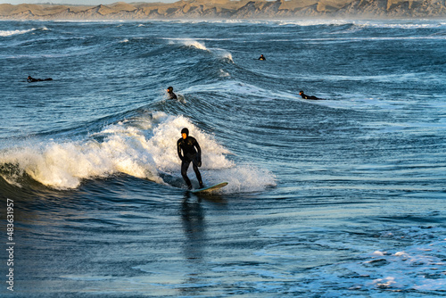 Surfer catching waves in cold water in winter, cold hawaii, norre vorupor, Klitmoller and Hanstholm, denmark