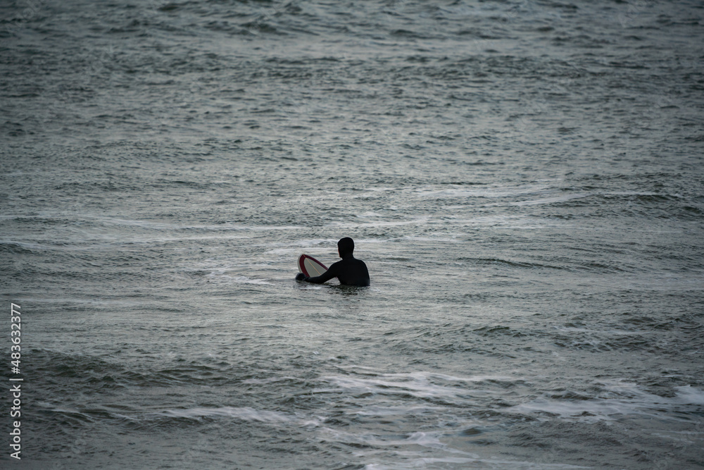 Surfer wait to catching waves in cold water in winter, cold hawaii, norre vorupor, Klitmoller and Hanstholm, denmark