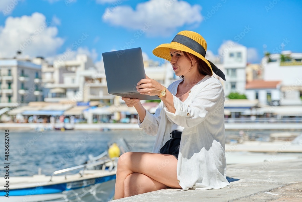 Portrait of woman in hat with laptop talking on video communication using laptop