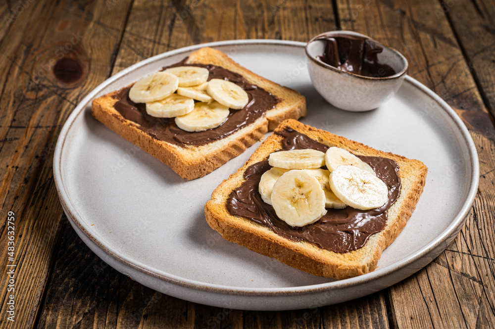 Cooking of sandwich with chocolate Hazelnut butter and bananas. Wooden background. Top view