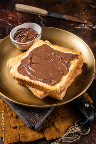 Stack of Toasts with chocolate Hazelnut cream in plate. Dark background. Top view