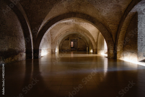 Empty cellar with electric light and old historic arches