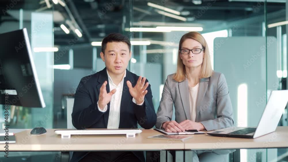 a team of business employees at an online meeting look at camera and communicate. Webcam view. conference remote interview. Two office workers talking Video call conversation. Asian male and female a team of business employees at an online meeting look at camera and communicate. Webcam view. conference remote interview. Two office workers talking Video call conversation. Asian male and female