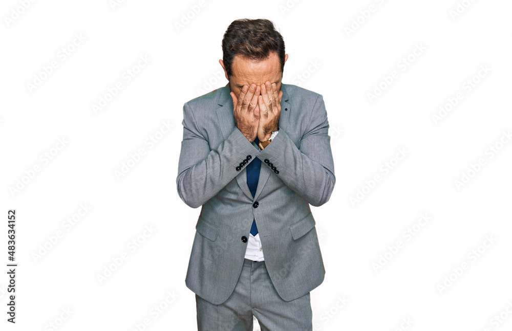 Middle age man wearing business clothes with sad expression covering face with hands while crying. depression concept. Middle age man wearing business clothes with sad expression covering face with hands while crying. depression concept.