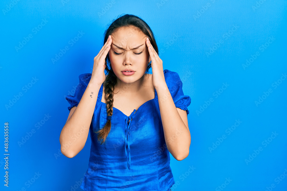 Young hispanic girl wearing casual clothes with hand on head for pain in head because stress. suffering migraine.