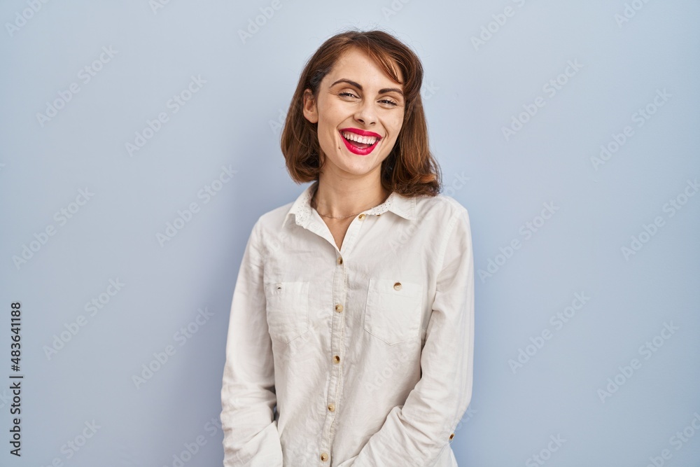 Young beautiful woman standing casual over blue background with a happy and cool smile on face. lucky person. Young beautiful woman standing casual over blue background with a happy and cool smile on face. lucky person.