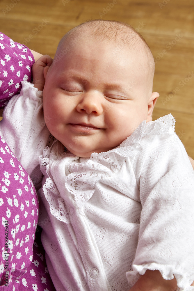 bébé fille 1 mois dormant dans les bras de sa mère caucasienne Stock Photo