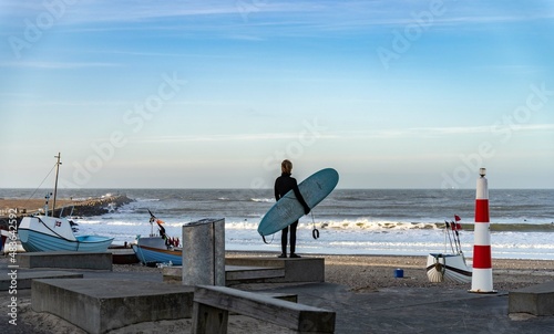 Surfer wait to catching waves in cold water in winter, cold hawaii, norre vorupor, Klitmoller and Hanstholm, denmark