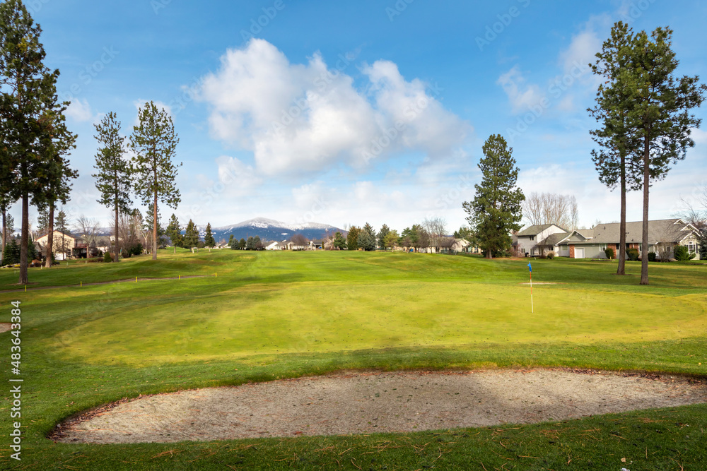 A tee, fairway and sand trap at golf course in a community of homes in Post Falls, Idaho, USA.