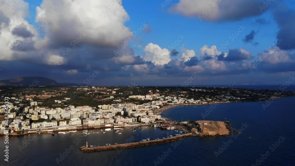 Beautiful sunny aerial view of tourist town at morning time, North coast of Crete island. Panorama of Hersonissos and port, white cumulus clouds on sky, calm sea water down Beautiful sunny aerial view of tourist town at morning time, North coast of Crete island. Panorama of Hersonissos and port, white cumulus clouds on sky, calm sea water down